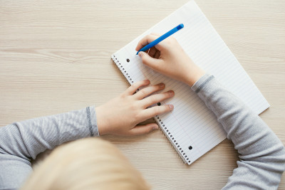 孩子拿着笔在写字。