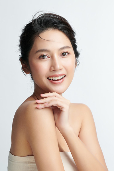 美丽年轻的亚洲女性与干净的新鲜皮肤在白色的背景，面部护理，面部治疗，美容和水疗中心，亚洲女性肖像。