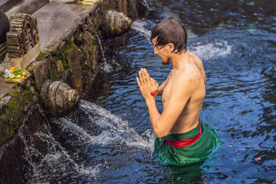 巴厘岛圣泉寺的人。寺庙由一个以其神圣的泉水而闻名的浴场结构组成