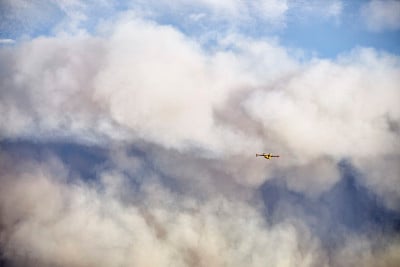 水上飞机在火山灰云中努力扑灭森林大火。自然灾害的概念