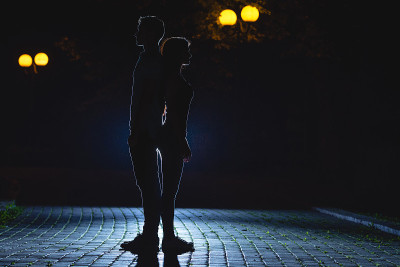 那男人和女人站在黑暗的街道上。晚上的时间