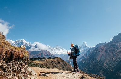 年轻的徒步背包客男子与徒步杆享受Ama Dablam 6814米的山峰在高海拔适应行走。珠峰大本营路