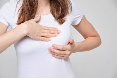 这个女孩正在按摩她的乳房。疾病或癌症筛查概念。
