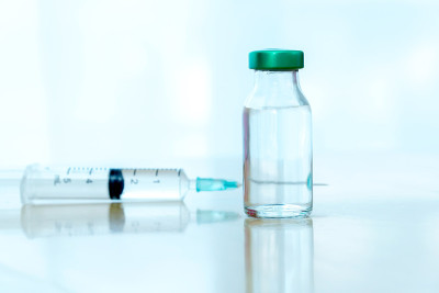 近距离疫苗对抗病毒，医生或科学家在实验室拿着一个注射器与液体疫苗。
