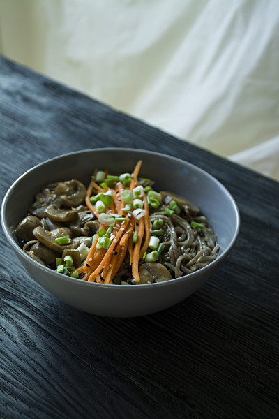 荞麦面配酱料和装饰。日本的食物。前视图。黑色板岩的背景。