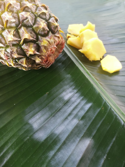 菠萝和它的片放在绿色的芭蕉叶。