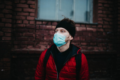 一名年轻人在疫情期间戴着医用口罩。