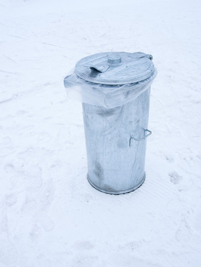 金属垃圾桶因雪融化而盖湿