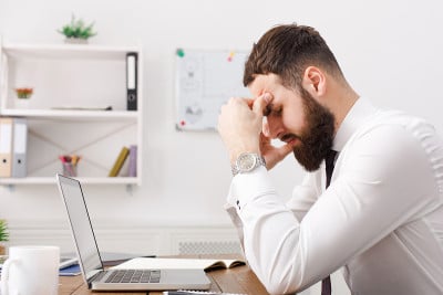 年轻疲惫的商人在白色的办公室里思考解决方案