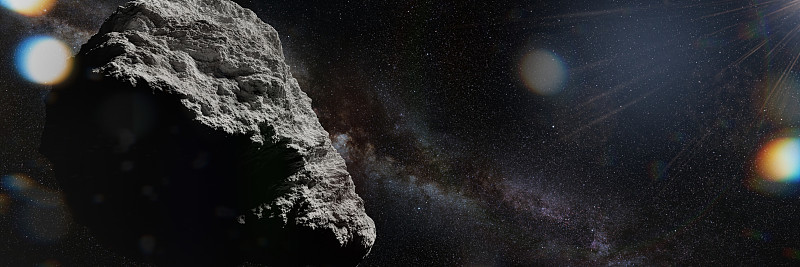 太空中的小行星被太阳照亮，旗帜格式的背景