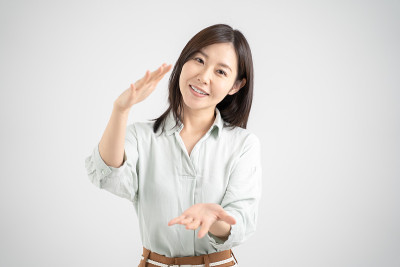 女性微笑着解释服务，白色的摄影背景