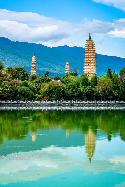垂直的大理三塔崇生寺与水的倒影和蓝天在中国云南大理