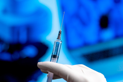 医生手持注射疫苗注射器。SARS冠状病毒、新型冠状病毒的实验室药物研究