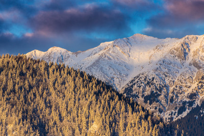 冬天的风景在山上，有白雪覆盖的山峰和落日的月亮