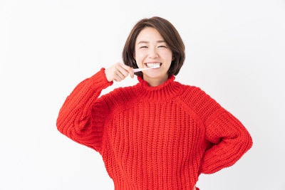 漂亮的亚洲女人用健康的牙齿拿着牙刷，口腔护理