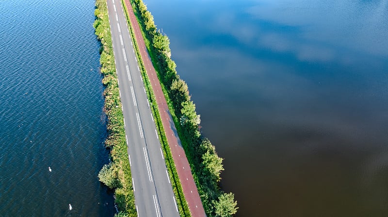 无人机俯瞰荷兰北部的高速公路和圩坝上的自行车道，上面的汽车交通