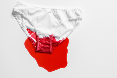Menstrual fluid and women's underwear on white bac