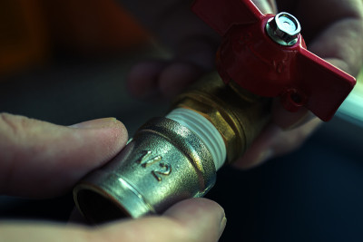 水管工手在管道工具上拧螺母的背景。修理和技术援助的概念。近距离射杀。残酷atristic塑身