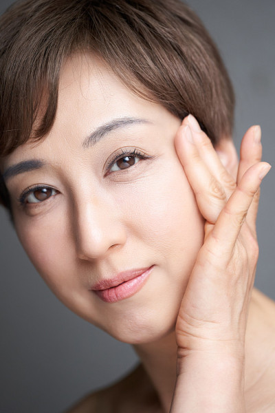 一位中年日本妇女，她抱着眼角微笑