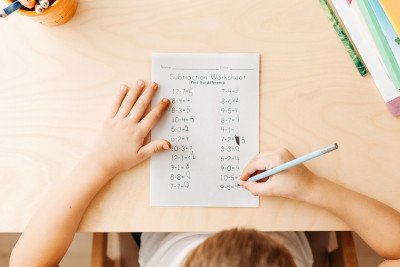 俯视图与铅笔的孩子的手。解决数学练习