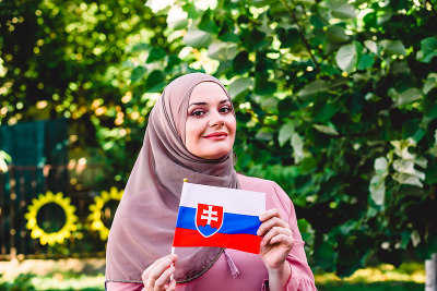 Muslim woman in hijab holds flag of Slovakia