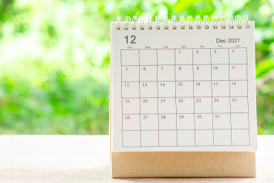 12月，在绿色自然背景的木桌上，为组织者规划和提醒2021日历桌。