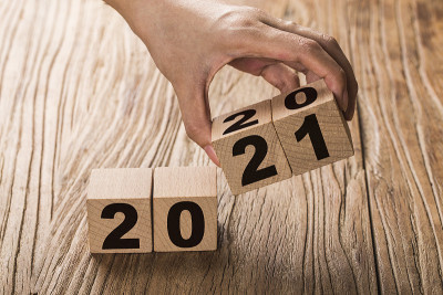 手翻转一个方块改变2020年到2021年。新的一年开始。假日和圣诞节。