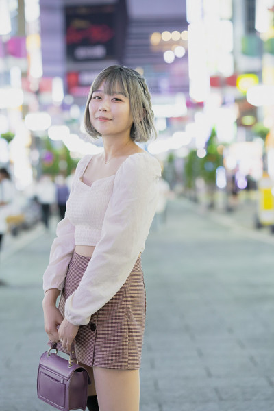 一名年轻女子晚上在东京摆造型