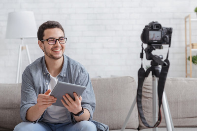 Young attractive man blogger looking at camera and