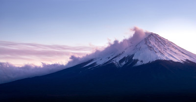 日落时分，日本富士山上覆盖着云雪。