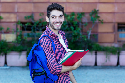 笑着走向大学的西班牙男学生