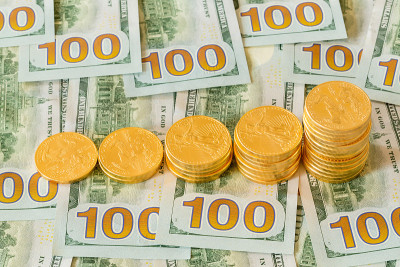 金币堆在新设计的100美元纸币上