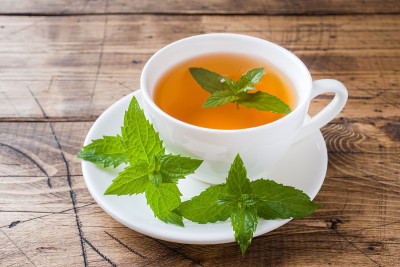 木桌上放着一杯薄荷和红糖热茶