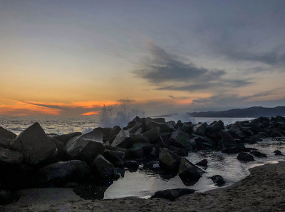 在威尼斯海滩，海浪撞击岩石，在冬天日落