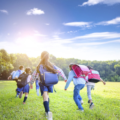 rear view of elementary school kids running on the
