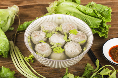木板背景上的一碗牛肉丸子汤