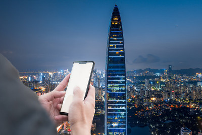 手握手机在深圳的高层建筑