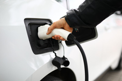 那人把一根加油管插入汽车