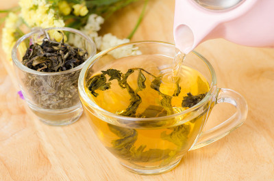 将茶壶中的热茶倒入杯子