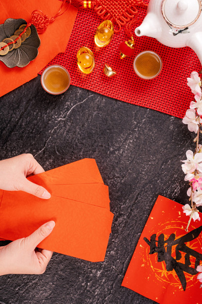 中国农历一月新年的设计理念——女人拿着，给红包(ang pow，红包)作为压岁钱，俯视图，平躺，头顶