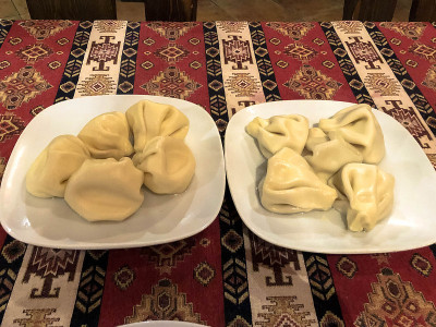 两份营养美味的khinkali, manti陶瓷白色盘子上的桌子在国家格鲁吉亚餐厅的桌子上与红色桌布