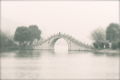 在中国，一个孤独的旅行者正穿过湘湖的一座桥