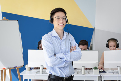 亚洲男性服务台操作员在呼叫中心摆姿势和微笑的肖像