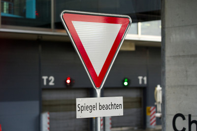 一个下雨天，Zürich机场码头中场的交通标志上写着“Spiegel beachten”(德语，翻译
