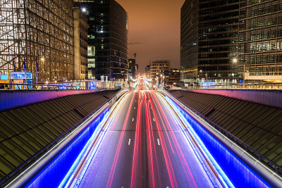穿过商业区的一条繁忙道路的夜景。光线轨迹。