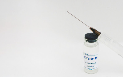 安瓿与covid-19疫苗和注射器白色背景。