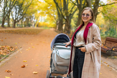 带着婴儿车在公园里微笑的妈妈
