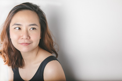 近距离拍摄美丽和漂亮的亚洲女性模特与大约30岁的黑色背心显示新鲜和活泼从她的明亮的眼睛，白色的牙齿和