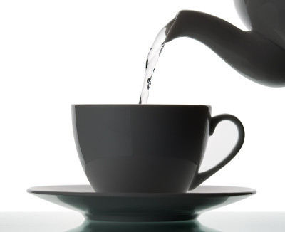 把开水倒进杯子的茶壶