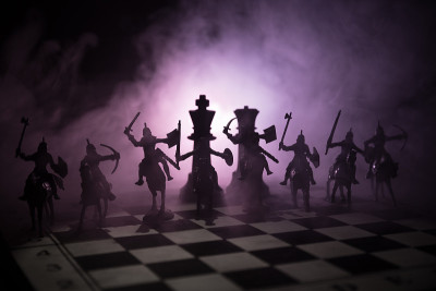 中世纪的战斗场景，骑兵和步兵在棋盘上。棋牌游戏的商业理念和竞争理念与战略理念棋牌人物在黑暗的背景下。